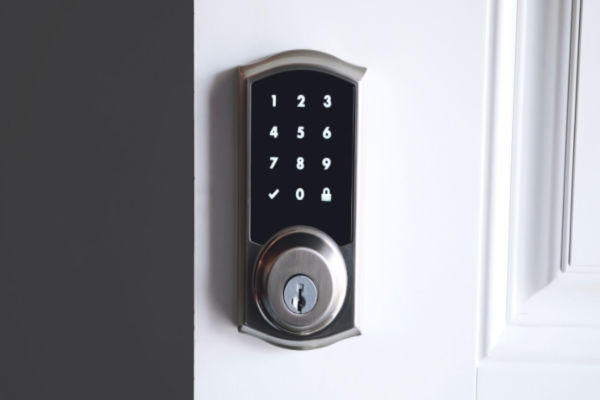 A close-up of a smart lock on a white door.