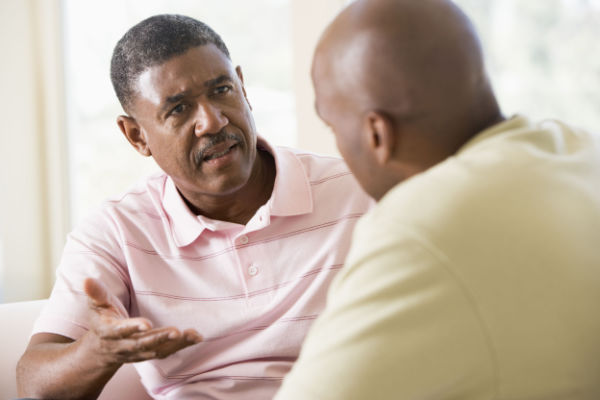 Two men sitting and engaging in serious conversation with each other. 