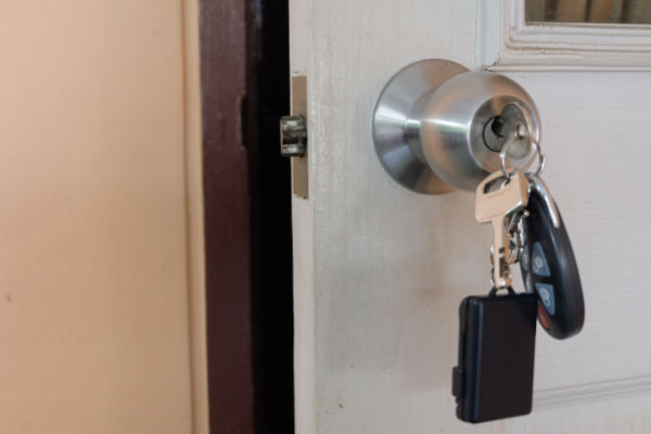 A set of keys in the door of a home, seemingly forgotten. 