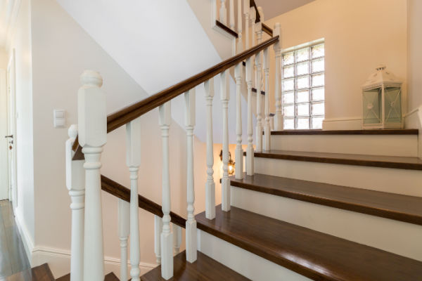 Two flights of white and dark brown wooden stairs in a home. . 