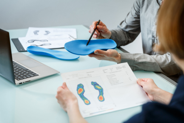A woman has an orthotics consultation with a professional. 