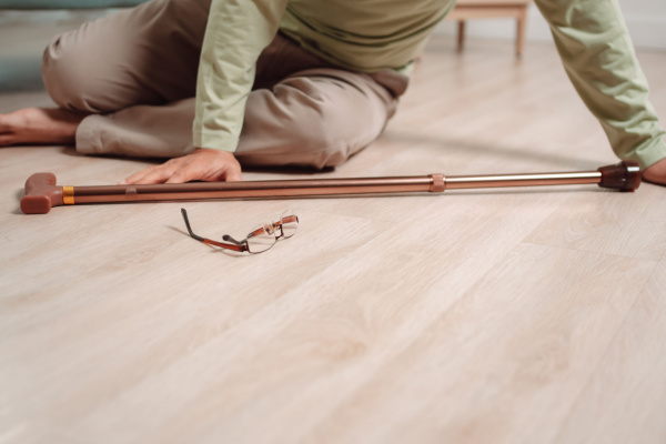 An elderly adult is on the floor after a fall. 