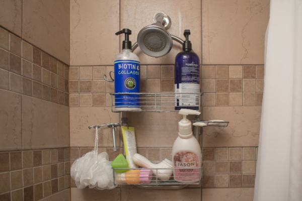 A shower caddy with shampoos, conditioners, shower wash, and a loofah. 