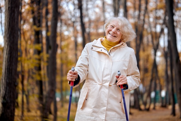 A smiling senior woman hikes outdoors.