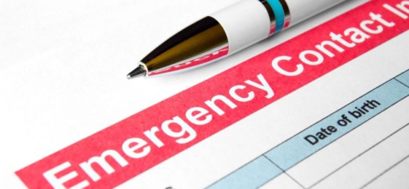 A pen sitting next to a list titled Emergency Contacts