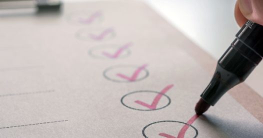 A checklist with checks in a circle. Another check is shown being added.