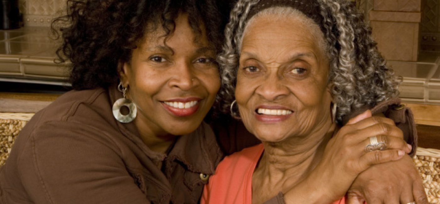 A daughter embraces her mother as they both smile.